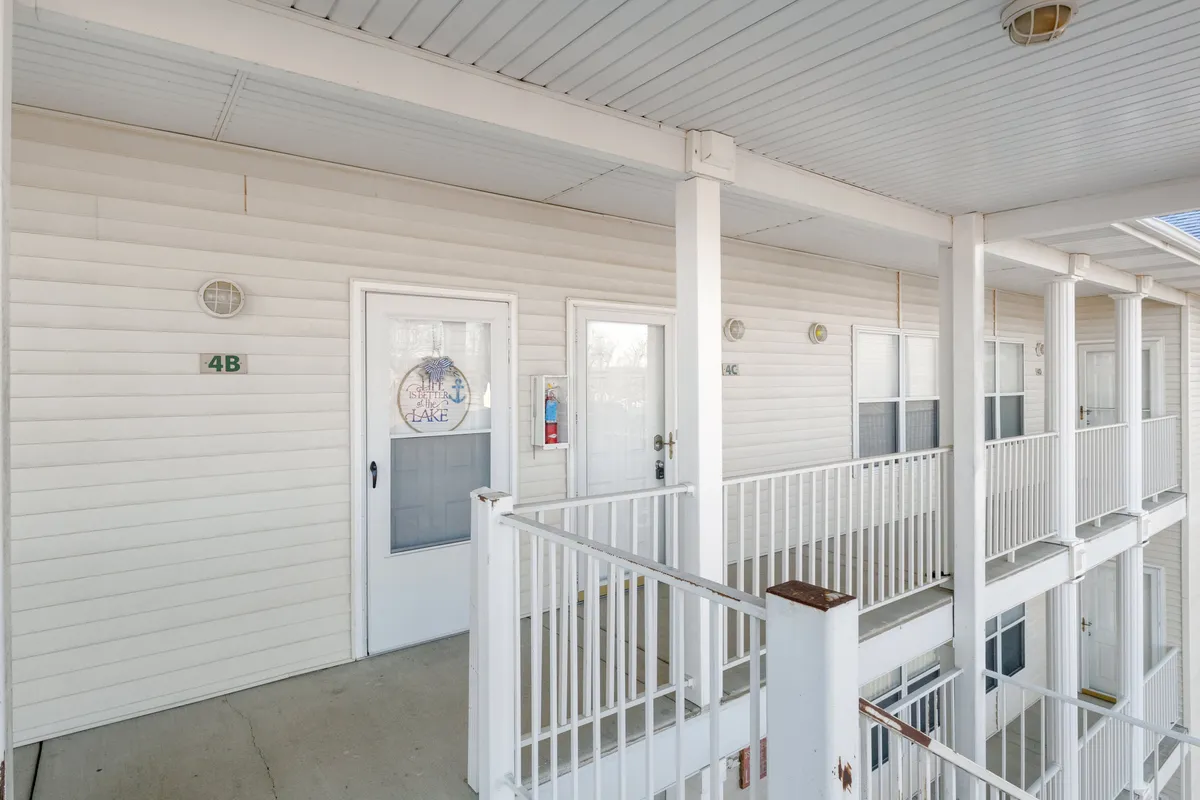 This image shows the front doors of the property, complete with inviting railings and numbered plaques. The scene offers a glimpse of outdoor balconies, suggesting a welcoming entrance and shared community spaces that connect the property to the surrounding area.